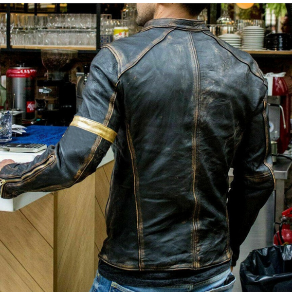 Back view of a person wearing a distressed black biker-style jacket with tan stitching