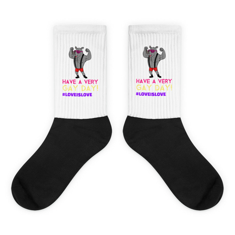 Pair of black-and-white socks with flexing rhinos and “HAVE A VERY GAY DAY!” text