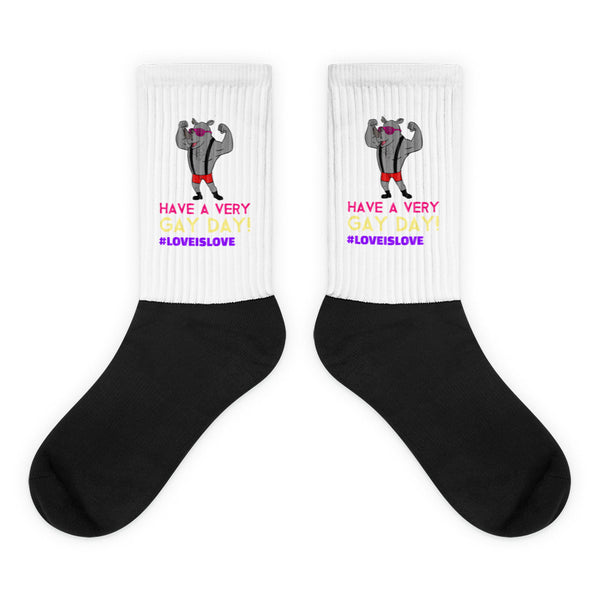 Pair of black-and-white socks with flexing rhinos and “HAVE A VERY GAY DAY!” text