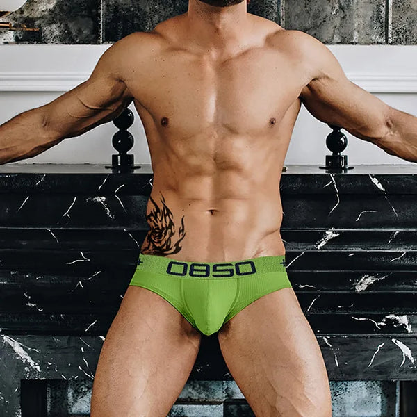 Model wearing bright green OBSO briefs with a dark logo waistband
