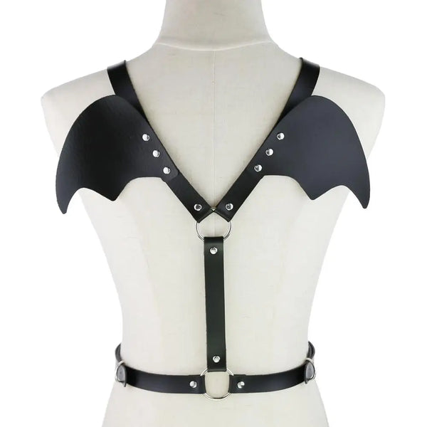 Black bat-wing chest harness with silver rivets, O-rings, and waist strap on a mannequin