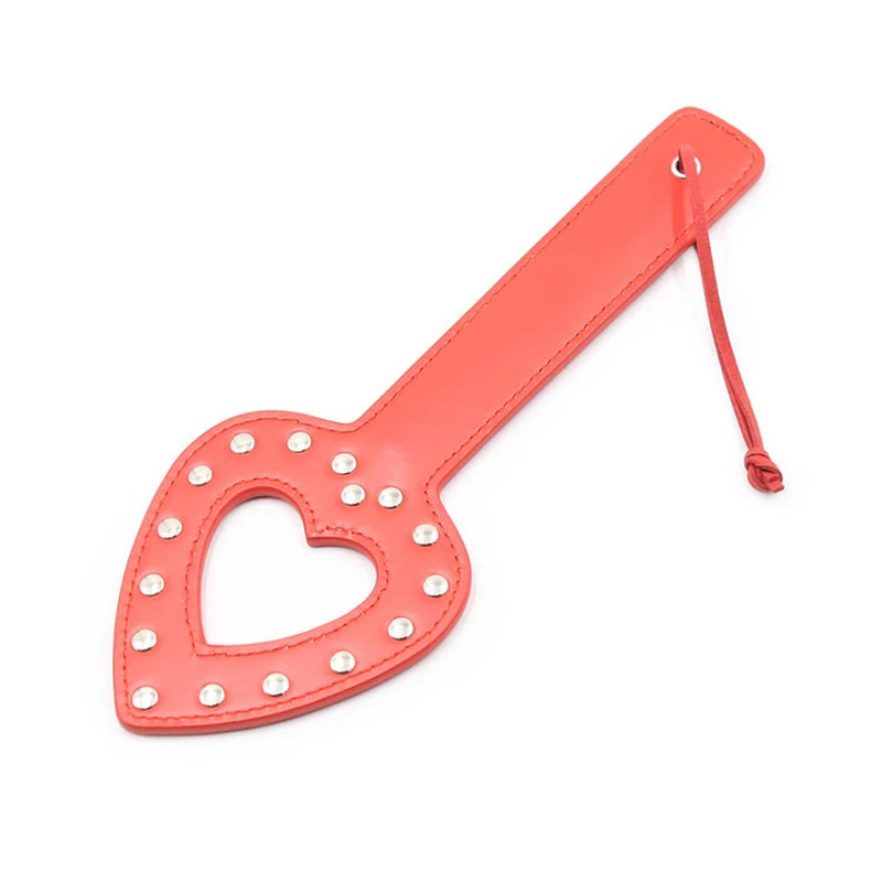 Red heart-shaped leather paddle with silver rivets and a wrist loop