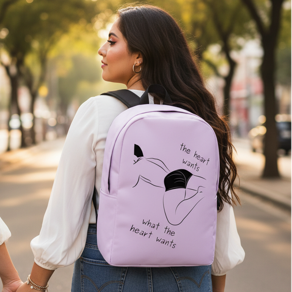 Minimalist light purple backpack reads “The Heart Wants What The Heart Wants” with a reclining figure