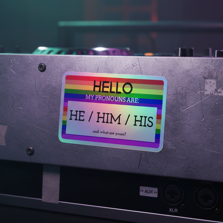 They/them/their holographic sticker with a rainbow border on metallic surface; bold pronouns text