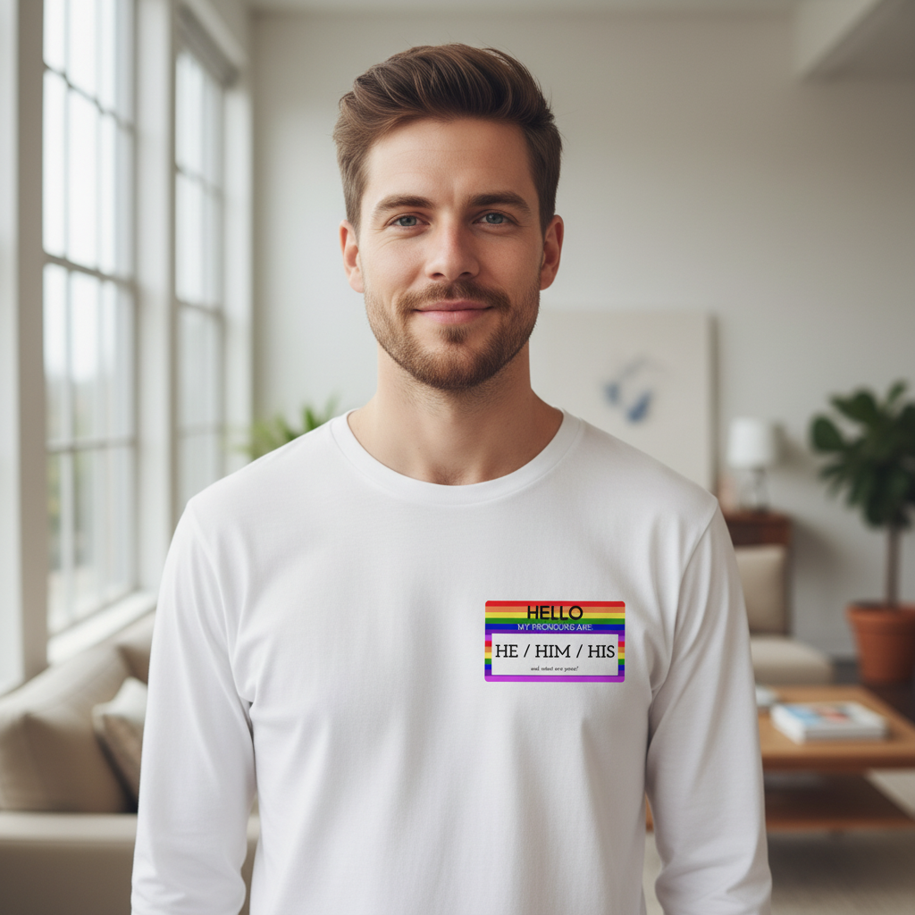 Unisex long sleeve tee with “Hello My Pronouns Are He / Him / His” and rainbow badge