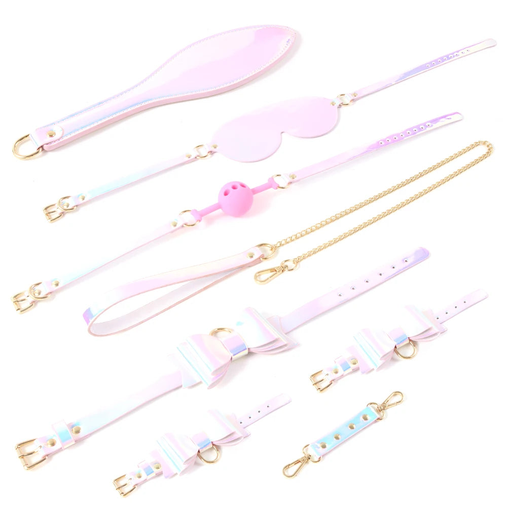 Flat lay of a pastel holographic BDSM restraint set with cuffs, blindfold, leash, and chain