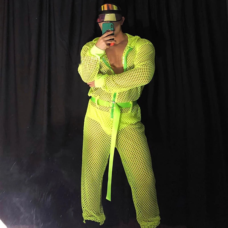 Front-facing person takes a mirror selfie in a fluorescent neon mesh hooded jumpsuit
