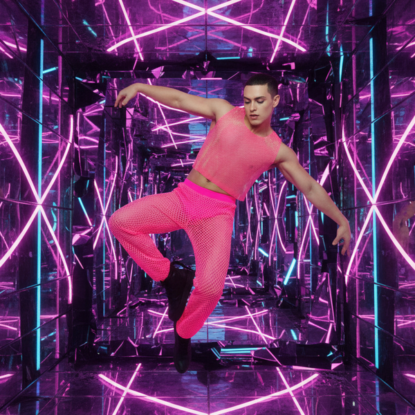 Model leaping in a hot-pink mesh crop top and matching pants