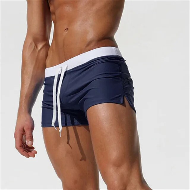 Side view of navy blue men's swim shorts with a white waistband and drawstring