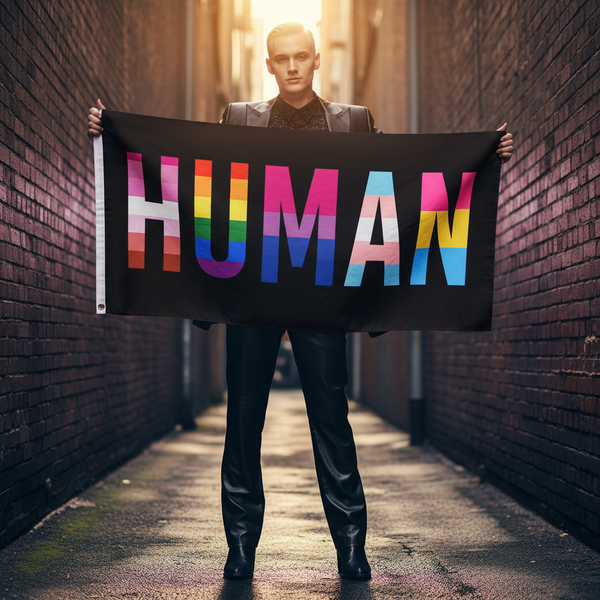 A person holds the HUMAN LGBT Pride Flag in a sunlit alley, with rainbow letters symbolizing unity and equality