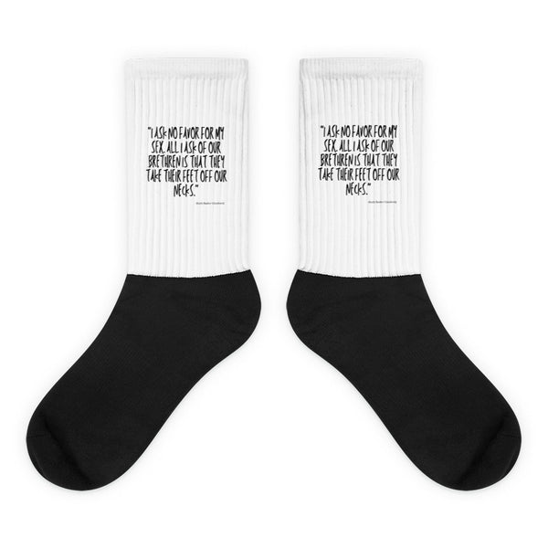 Pair of black-and-white socks with a Ruth Bader Ginsburg quote on the cuffs