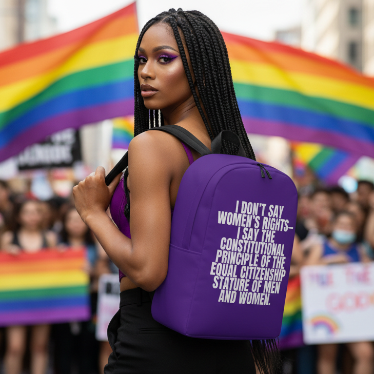 Minimalist backpack reading "I Don't Say Women's Rights" held by braided person at Pride