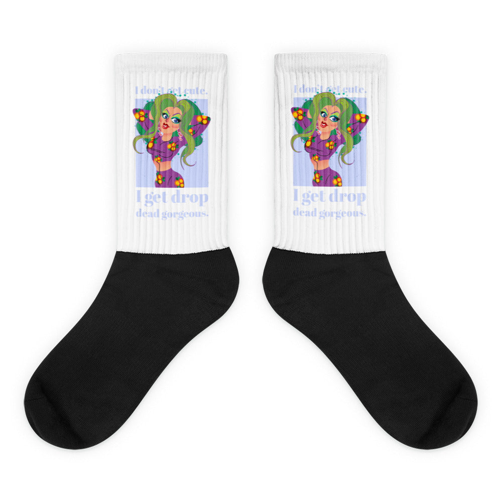Pair of white-and-black socks with a green-haired cartoon woman and “I get drop dead gorgeous” text
