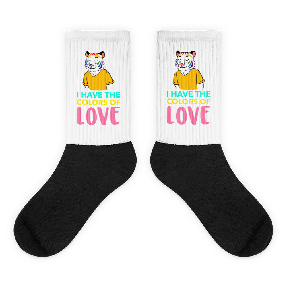 Pair of black-and-white crew socks reading “I HAVE THE COLORS OF LOVE”