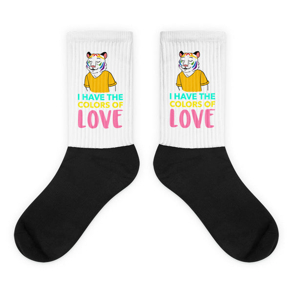 Pair of black-and-white crew socks with rainbow tiger graphics and “I HAVE THE COLORS OF LOVE” text