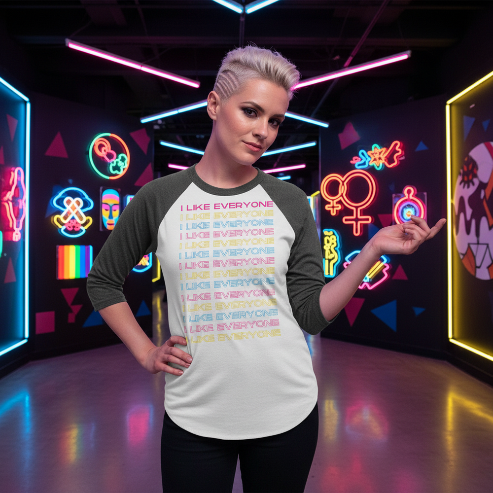 I Like Everyone 3/4 sleeve raglan shirt with rainbow lettering, worn by a platinum-haired person in a neon LGBTQ+ space