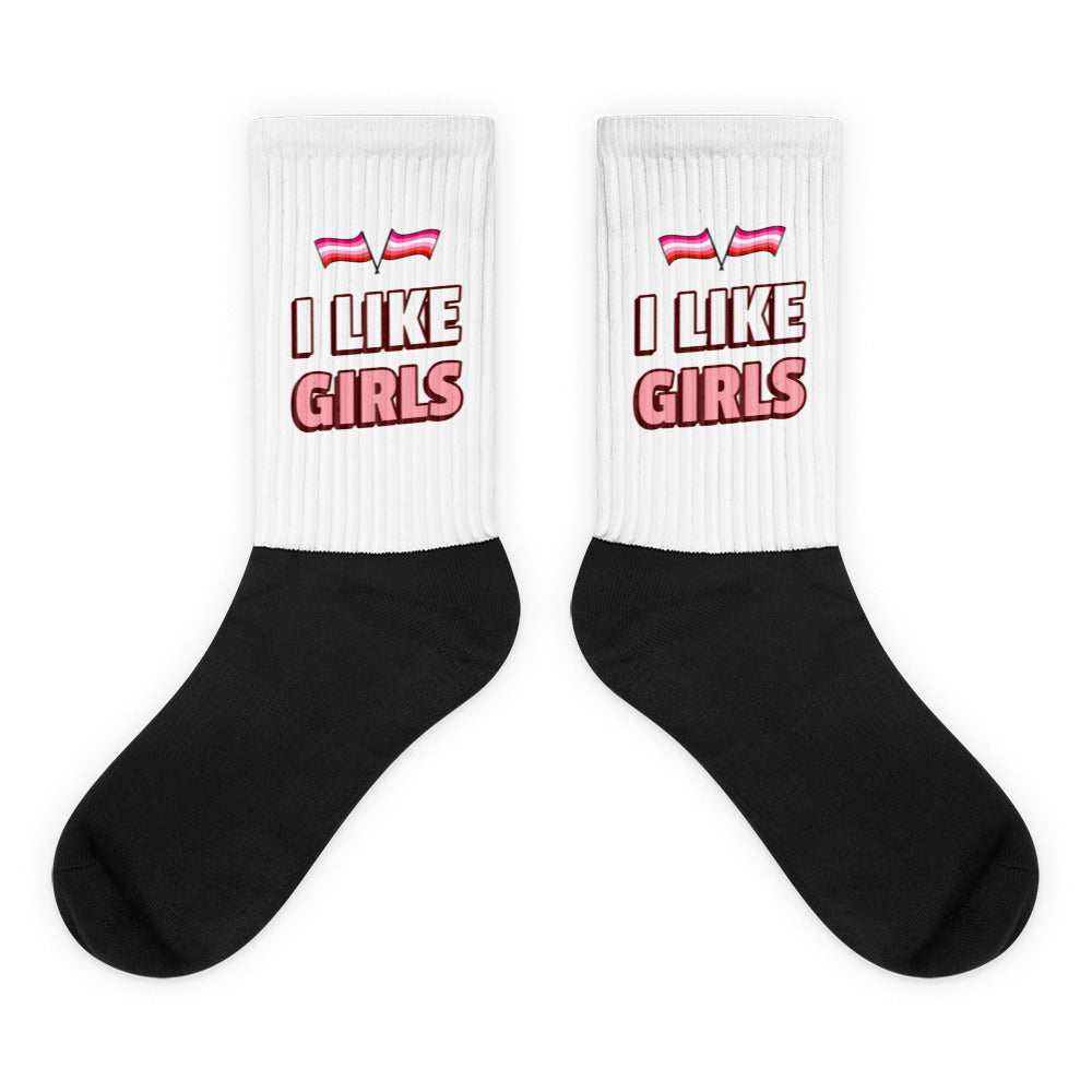 Pair of white-and-black crew socks reading “I LIKE GIRLS” with pink stripes