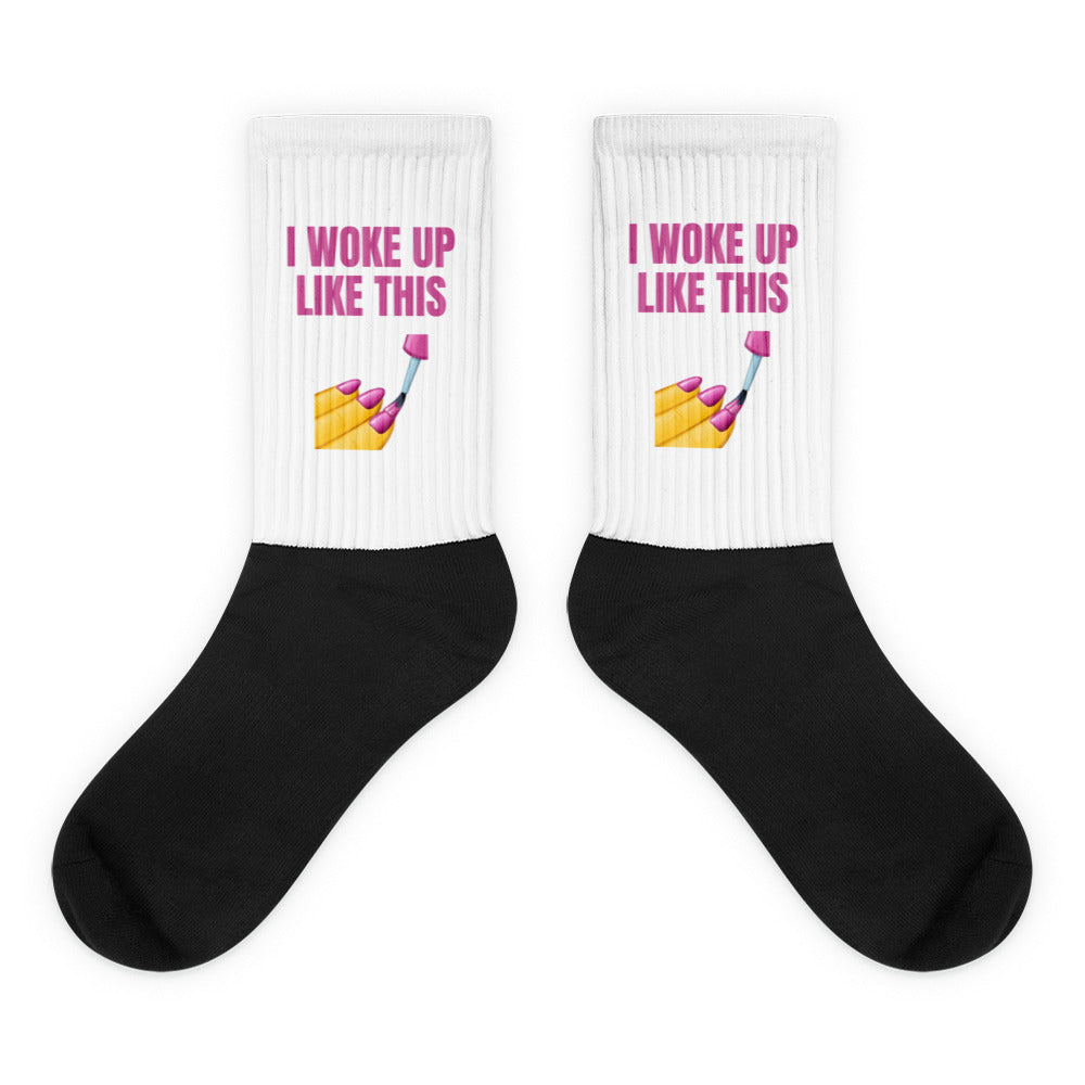 Pair of black-and-white socks reading “I WOKE UP LIKE THIS” with a nail-painting graphic