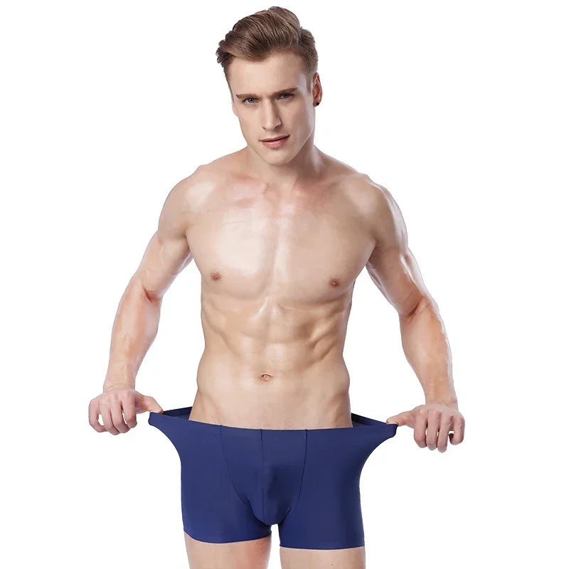 Front-facing model stretches the waistband of navy boxer briefs against a white background