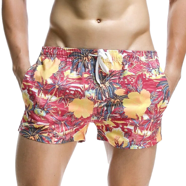 Front view of a model wearing red tropical floral swim shorts with a white drawstring