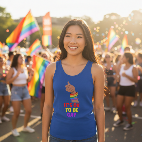 It's Ok to Be Gay unisex tank top worn by a smiling person with rainbow bracelets, surrounded by pride flags and balloons