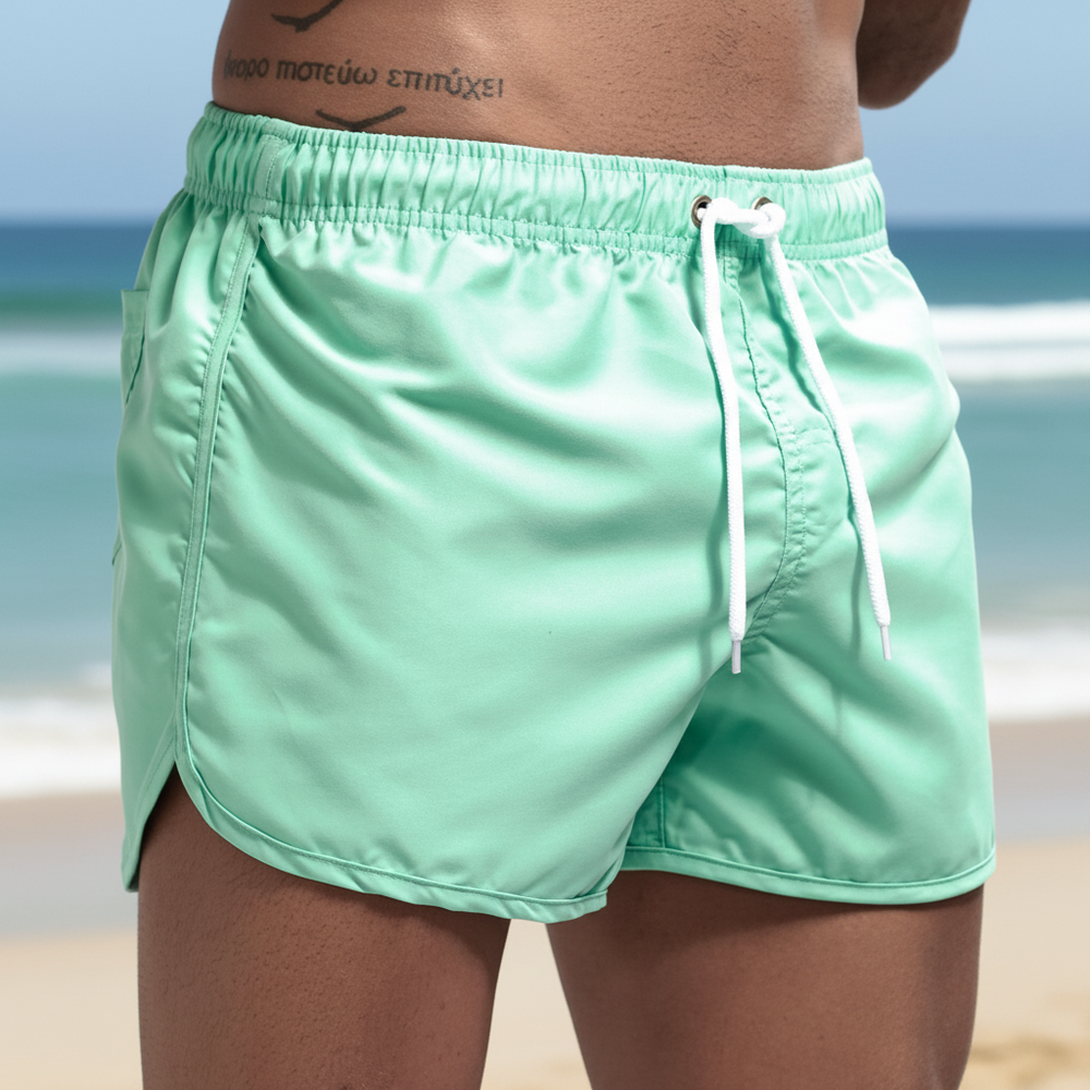 Lower torso and upper thighs with a lower abdomen tattoo in Jockmail Classic Mint Green Swim Shorts with white drawstrings