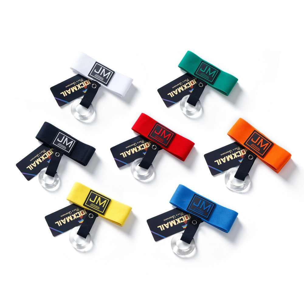 Flat lay of Jockmail cockstraps in white, green, black, red, orange, yellow, and blue