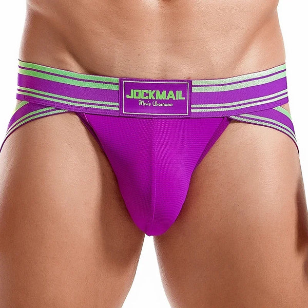 Front view of a model wearing a bright purple jockstrap with green striped waistband