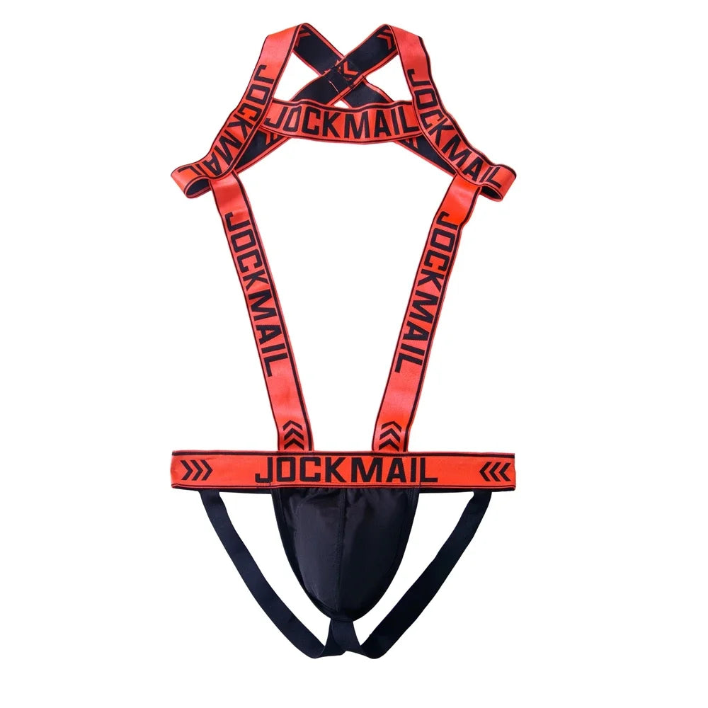 Flat lay of a red-and-black Jockmail thong harness with crossed shoulder straps