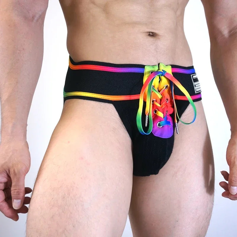 Front view of a model wearing a black rainbow-trim jockstrap with a colorful detachable pouch