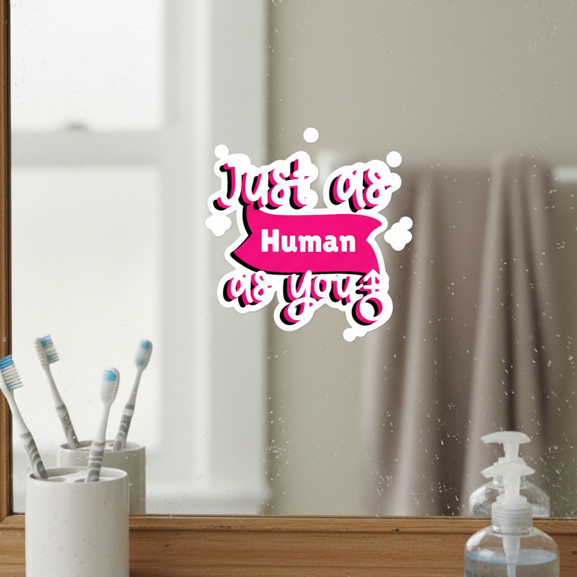 Just As Human As You bubble-free sticker in pink and white pride colors on bathroom mirror, shelf with toothbrushes, soap