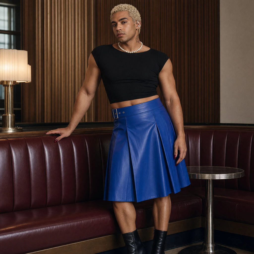 Model wearing a cobalt blue leather-look pleated kilt with a black crop top and pearls in an Art Deco lounge