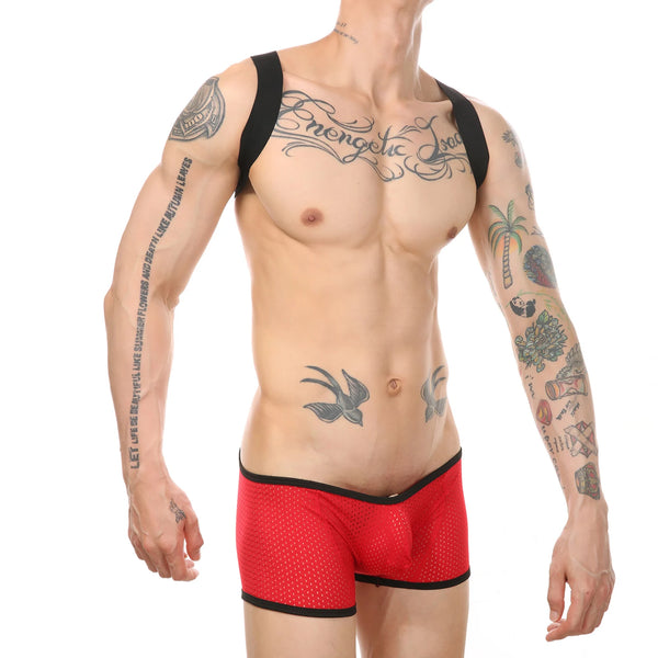 Front view of a tattooed model wearing a black-strap red mesh wrestling bodysuit