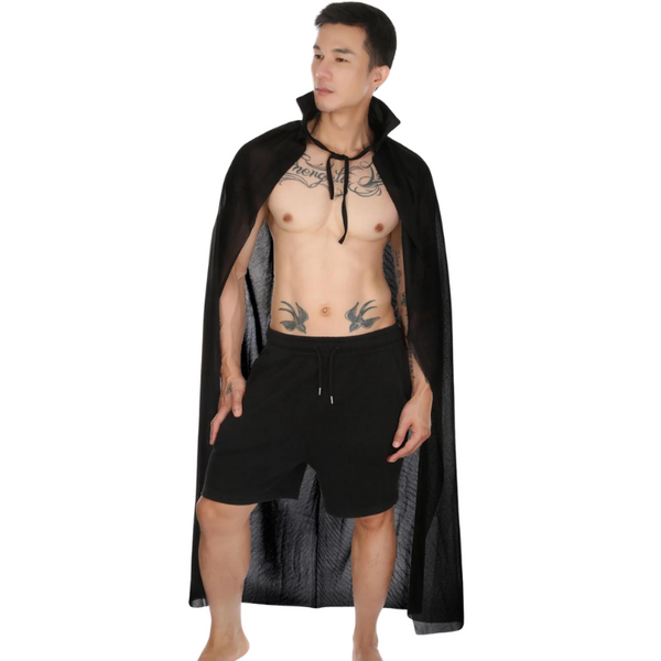 Shirtless model wearing a black sheer cape and black drawstring shorts