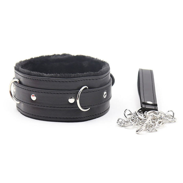 Black faux-leather bondage collar with fur lining, metal rings, and a detached chain leash