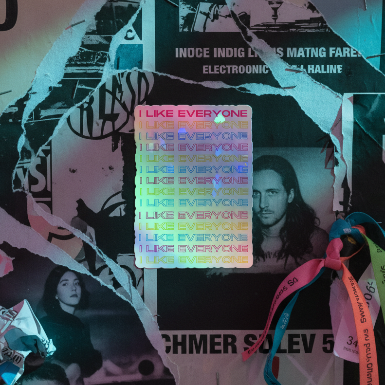 Holographic stickers repeat “I LIKE EVERYONE” over a torn black-and-white collage, with rainbow shimmer and wristbands, lit blue-pink.