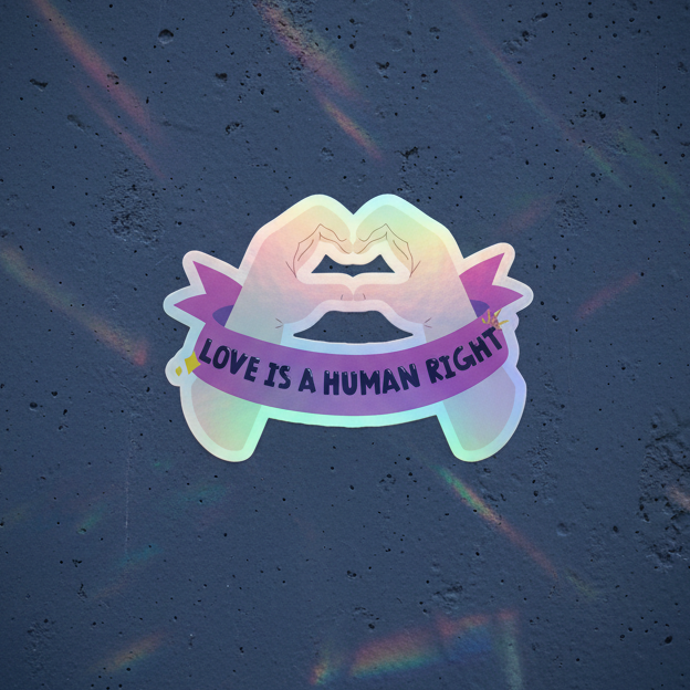 Holographic “Love Is A Human Right” sticker with pastel rainbow-outlined kissing lips, purple banner, queer vibes on dark backdrop.