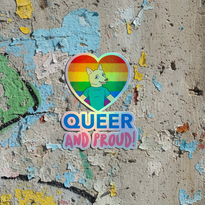 Holographic "QUEER AND PROUD!" vinyl sticker shows a cartoon dog in blue shirt inside a rainbow heart; blue, pink text pops.