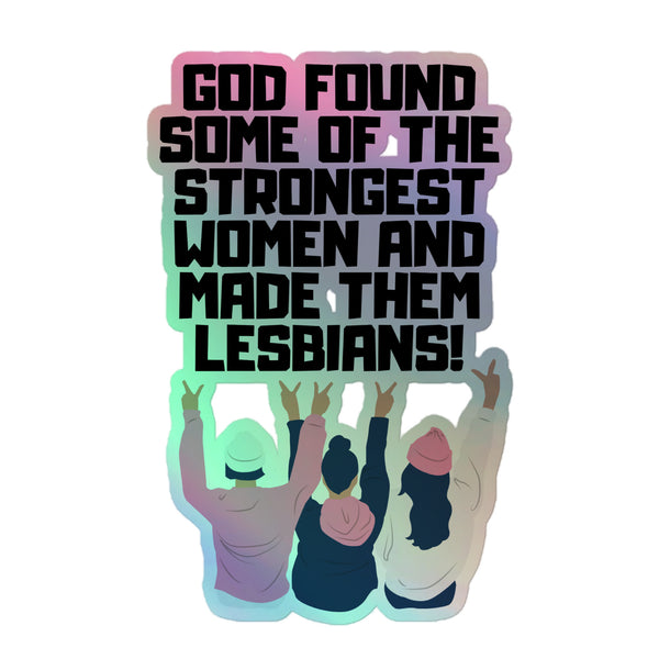 Holographic sticker shows three women from behind throwing peace signs, framed by rainbow shimmer and bold text: “God found some of the strongest women and made them lesbians!”.