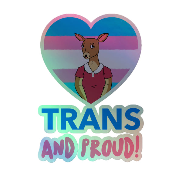 Trans And Proud Holographic Stickers feature a heart-shaped transgender pride flag backdrop, showcasing an anthropomorphic deer in a reddish-pink shirt. Bold text below reads “TRANS AND PROUD!”, celebrating vibrant queer self-expression.