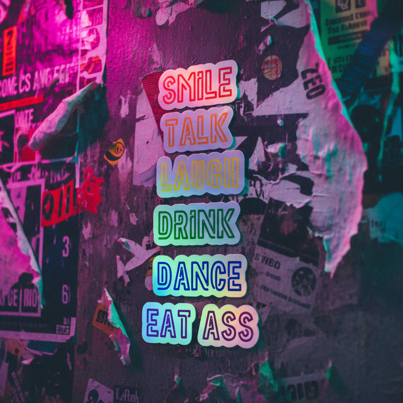 Rainbow holographic vinyl stickers reading “Smile, Talk, Laugh, Drink, Dance, Eat Ass” pop against a queer graffiti wall.