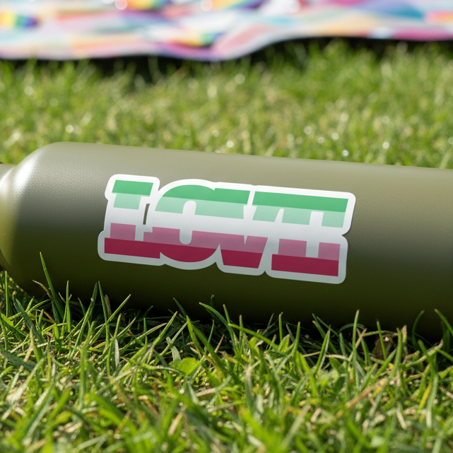 Green water bottle on grass with an Abrosexual Pride sticker—green, white, pink stripes—vinyl. Colorful blanket behind.