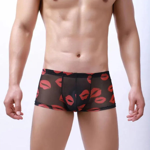 Front view of a model wearing black sheer boxer briefs with red lip prints