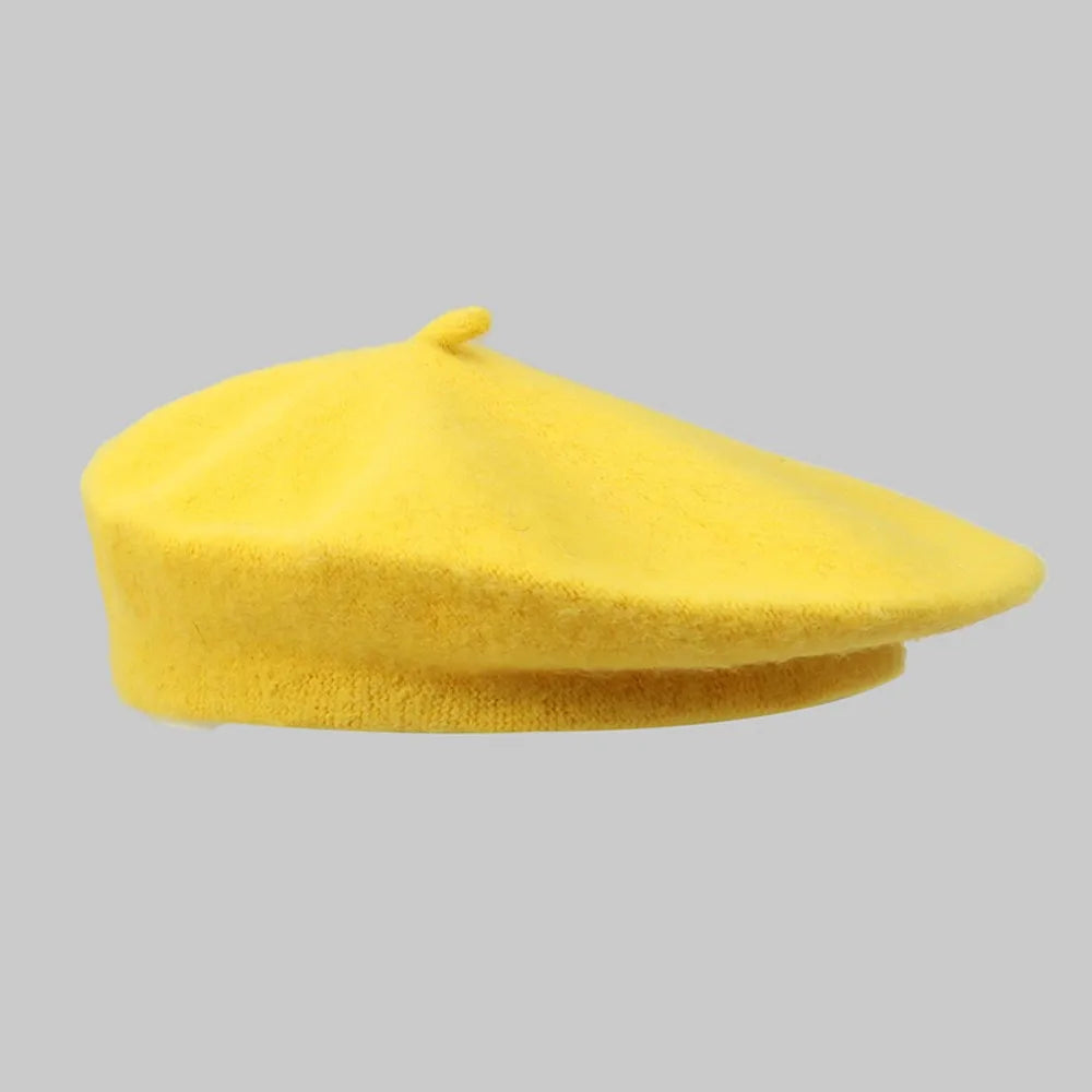 Side view of a bright yellow wool beret on a gray background