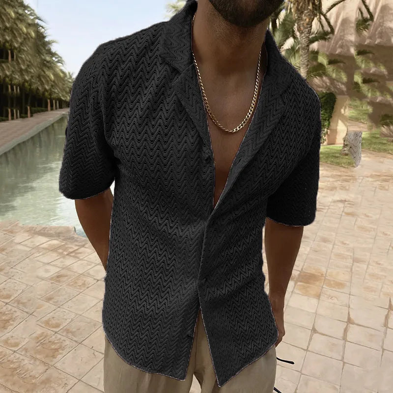 Front view of a person wearing a black textured cutout shirt by a pool