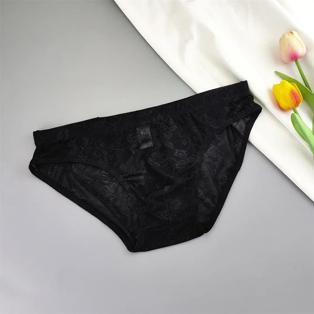 Black lace briefs laid flat beside a white cloth and colorful tulips