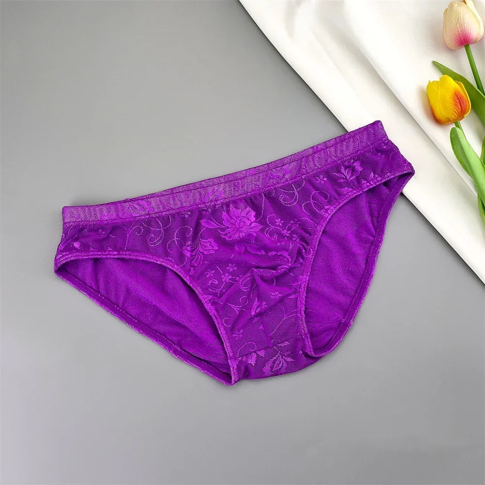 Purple lace briefs laid flat at an angle beside white fabric and tulips