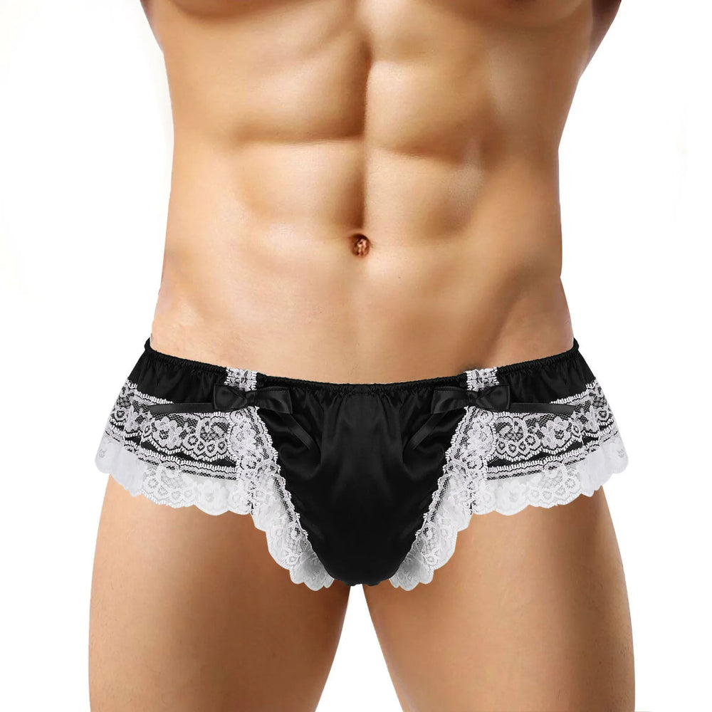 Front view of a model wearing black satin briefs with white lace trim and bows