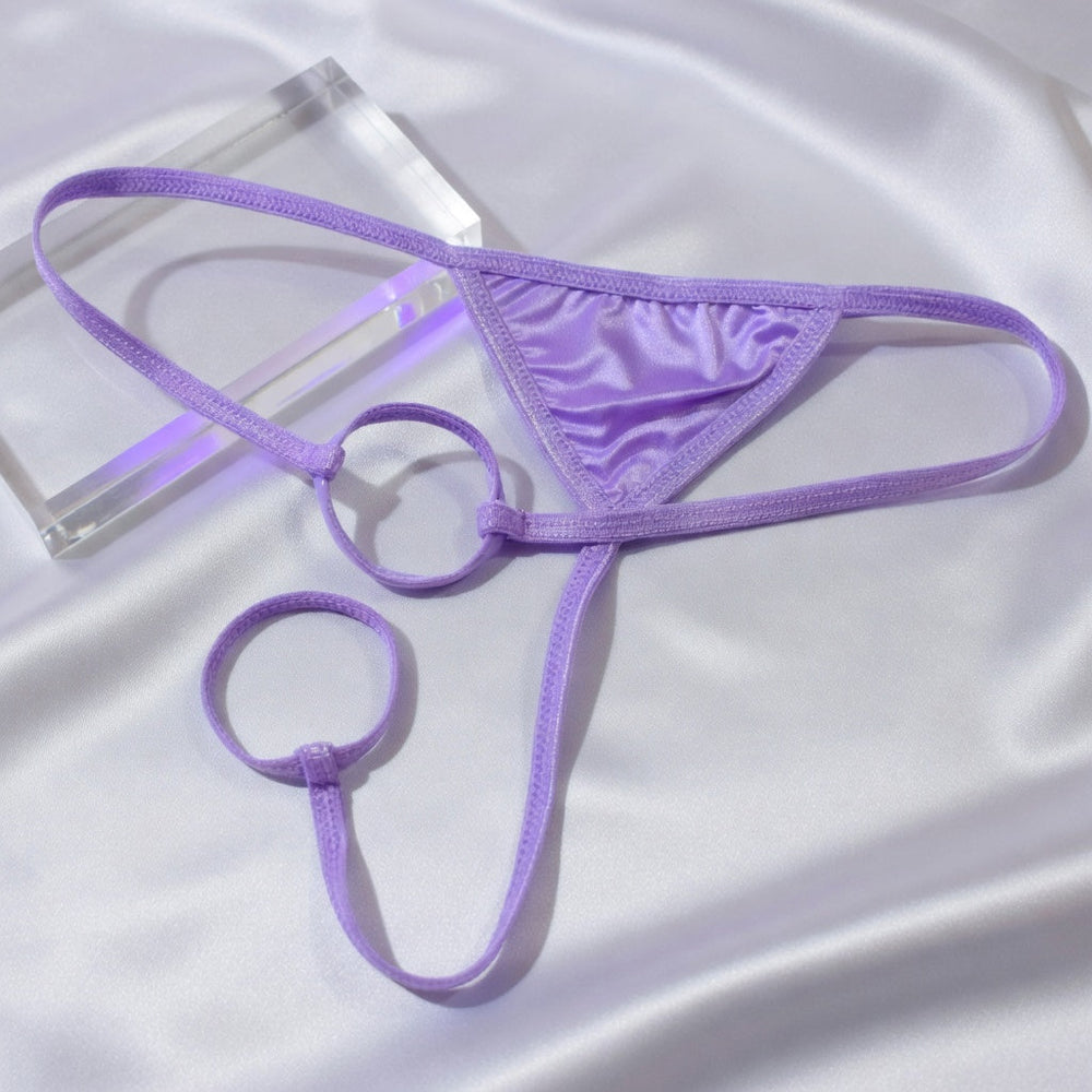 Lavender strappy men's underwear with circular rings arranged on satin and clear acrylic.