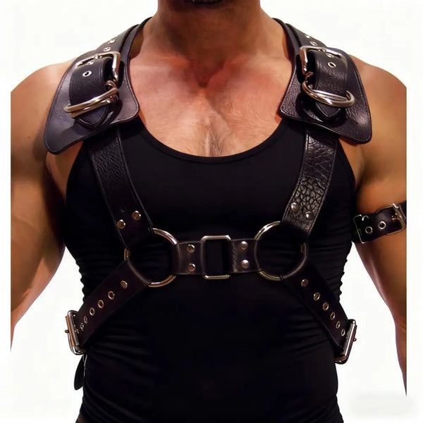 Front view of a person wearing a black leather chest harness with metal rings and buckles